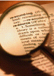 Magnifying glass looking up a resource in a book